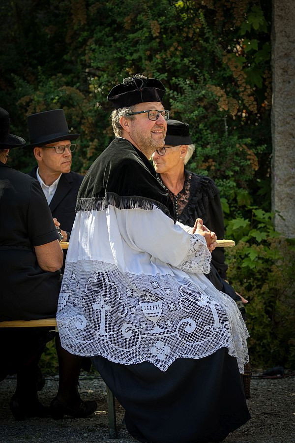 Pfarrer, Ehrengesell und Schlotterkölle verfolgen die Zeremonie.